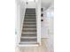 Carpeted staircase leading to a finished basement with storage shelving at 4571 Beach Ct, Denver, CO 80211