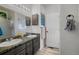 Well-lit bathroom featuring double sinks, modern fixtures, and wood-look flooring at 2321 Ance St, Strasburg, CO 80136