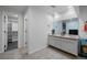 Bright bathroom with double sinks, vanity with storage, and a walk-in closet at 2321 Ance St, Strasburg, CO 80136
