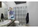 Bathroom featuring a shower with a patterned curtain, tiled floor and modern fixtures at 2321 Ance St, Strasburg, CO 80136