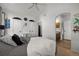 Bright bedroom features a ceiling fan, plush bedding, and ensuite bathroom access at 2321 Ance St, Strasburg, CO 80136