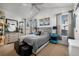 Sunlit bedroom with a tufted headboard, display cabinet, and plentiful natural light at 2321 Ance St, Strasburg, CO 80136