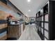 Inviting living room with wood-look accent wall, modern bar area, and shelving for storage and display at 2321 Ance St, Strasburg, CO 80136