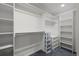 Spacious walk-in closet with built in shelving and hanging racks for optimal storage space at 2321 Ance St, Strasburg, CO 80136