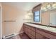 Bathroom featuring double sinks, wood cabinets, a large mirror, and neutral finishes at 620 State Highway 52, Erie, CO 80516