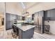 Spacious kitchen with stainless appliances, large center island, and modern gray cabinetry at 620 State Highway 52, Erie, CO 80516