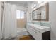 Bathroom featuring double sink vanity, tiled shower and bath, and modern finishes at 3354 Vallejo St, Denver, CO 80211
