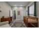 Bedroom with wooden crib, large rug, and view to hall and closet at 3354 Vallejo St, Denver, CO 80211