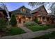 Charming two-story home with a stone and wood porch, blossoming landscaping, and a well-maintained front yard at 3354 Vallejo St, Denver, CO 80211