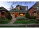 Charming home with stone accents, covered porch, and landscaped front yard at dusk at 3354 Vallejo St, Denver, CO 80211