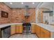 Modern kitchen with stainless steel appliances, exposed brick, and white countertops at 3354 Vallejo St, Denver, CO 80211