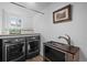 Laundry room featuring front loading washer/dryer, sink, and storage at 3354 Vallejo St, Denver, CO 80211