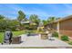 Backyard featuring a patio area with outdoor seating, fire pit, grill, mature trees, and fenced perimeter at 6180 W 77Th Pl, Arvada, CO 80003