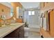 Charming bathroom features a decorative vanity, round mirror, and tub with white subway tile surround at 6180 W 77Th Pl, Arvada, CO 80003
