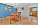 An interior photo of a dining room with hardwood floors and a wooden table with chairs and a bench at 6180 W 77Th Pl, Arvada, CO 80003