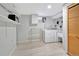 Bright laundry room with modern washer and dryer, practical shelving, and ample storage space at 6180 W 77Th Pl, Arvada, CO 80003