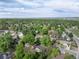 Suburban aerial view of a neighborhood featuring green trees and residential streets on a sunny day at 7695 S Harlan St, Littleton, CO 80128