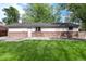 Large, level backyard featuring well-kept lawn with access to house and bordered with gravel at 7695 S Harlan St, Littleton, CO 80128