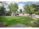 Expansive backyard featuring a storage shed, ample green space, mature trees, and a wooden fence at 7695 S Harlan St, Littleton, CO 80128