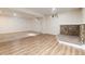 Partially finished basement with carpeted and vinyl flooring, and a stone fireplace at 7695 S Harlan St, Littleton, CO 80128