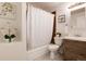 Well-maintained bathroom featuring a tub, shower, and wood-look vanity at 7695 S Harlan St, Littleton, CO 80128