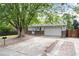 Charming single-Gathering home featuring mature trees, a spacious driveway, and an attached two-car garage at 7695 S Harlan St, Littleton, CO 80128