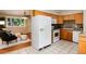 Open kitchen adjacent to living room, featuring tile floors, granite countertops, and appliances at 7695 S Harlan St, Littleton, CO 80128