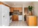 Well-lit kitchen featuring wooden cabinets, granite countertops, and white appliances at 7695 S Harlan St, Littleton, CO 80128