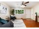 Sun-filled living room featuring hardwood floors, modern furnishings, and large windows with views of mature trees at 7695 S Harlan St, Littleton, CO 80128