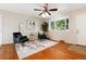 Cozy living room with hardwood floors, ceiling fan and a bay window overlooking the mature trees in the yard at 7695 S Harlan St, Littleton, CO 80128