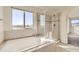 Bright bathroom featuring a soaking tub under a window and a glass-enclosed shower at 1960 E 166Th Dr, Thornton, CO 80602