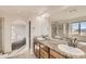 Bathroom featuring double sinks, wood cabinets, and a glass door shower at 1960 E 166Th Dr, Thornton, CO 80602