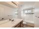 Bright bathroom featuring large mirror, neutral tile, and bathtub with shower at 1960 E 166Th Dr, Thornton, CO 80602