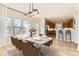 Dining area with modern light fixture seamlessly connects to the kitchen with stainless steel appliances at 1960 E 166Th Dr, Thornton, CO 80602