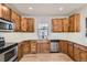 Spacious kitchen featuring wood cabinets, stone countertops, and stainless steel appliances at 1960 E 166Th Dr, Thornton, CO 80602