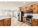 Stylish kitchen featuring wood cabinets, stainless steel appliances, and stone countertops at 1960 E 166Th Dr, Thornton, CO 80602