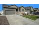 Inviting home featuring a two-car garage, stone facade, covered porch, and a nicely landscaped front yard at 2237 Barela Dr, Berthoud, CO 80513