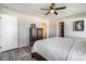 View of the main bedroom, wood floors, ceiling fan, and open doors to the bathroom and closet at 2237 Barela Dr, Berthoud, CO 80513