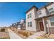 Contemporary two-story townhome featuring modern architecture, landscaping and a inviting red door at 19197 E 64Th Ave, Denver, CO 80249