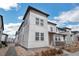 Modern townhome features a sleek, neutral-toned exterior with large windows and landscaped front yard at 19197 E 64Th Ave, Denver, CO 80249
