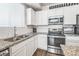 Modern kitchen with stainless steel appliances, granite countertops, and white cabinets at 19197 E 64Th Ave, Denver, CO 80249