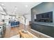 Open-concept living room and kitchen featuring hardwood floors, modern lighting, and stainless steel appliances at 19197 E 64Th Ave, Denver, CO 80249