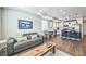 Open-concept living room and kitchen featuring hardwood floors, modern lighting, and stainless steel appliances at 19197 E 64Th Ave, Denver, CO 80249