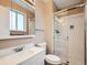 Functional bathroom featuring a sink, toilet, vanity mirror, and glass enclosed shower at 15769 E Greenwood Dr, Aurora, CO 80013