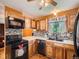 Traditional kitchen features wood cabinets, mosaic backsplash, black appliances, and light countertops at 15769 E Greenwood Dr, Aurora, CO 80013