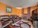 Comfortable living room featuring a brick fireplace, plush seating, and neutral carpeting at 15769 E Greenwood Dr, Aurora, CO 80013