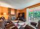 Inviting living room with brick fireplace, plush leather seating, and sliding door access to the deck at 15769 E Greenwood Dr, Aurora, CO 80013