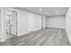 Finished basement boasts stylish gray wood floors and access to a modern bathroom at 4672 S Lewiston Way, Aurora, CO 80015