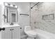 Stylish bathroom with marble tiled shower, black accents, and patterned floor tiles at 4672 S Lewiston Way, Aurora, CO 80015