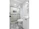 Elegant bathroom featuring marble shower, glass door, and patterned floor tiles at 4672 S Lewiston Way, Aurora, CO 80015